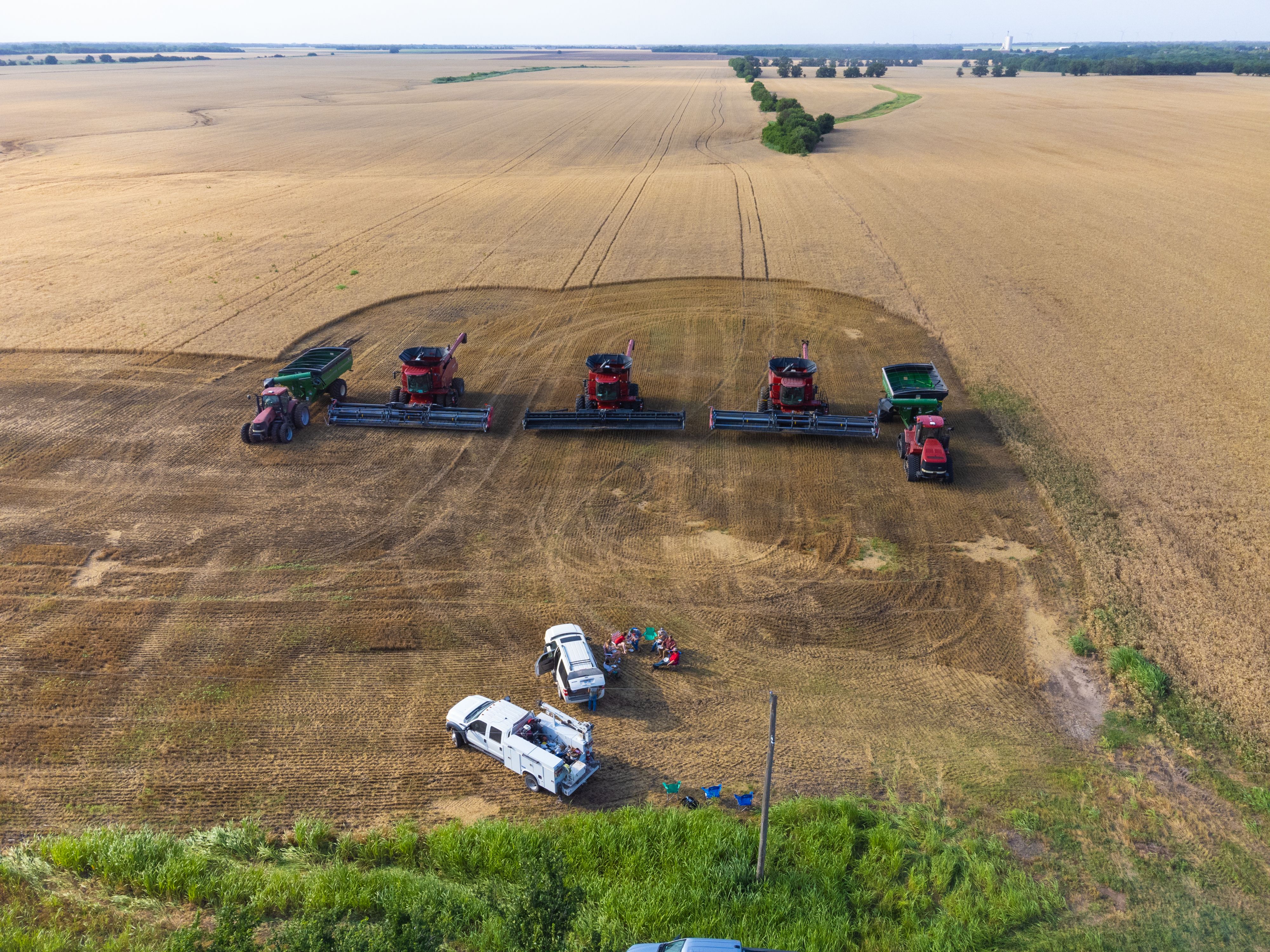 莫兰德一家停放好联合收割机、拖拉机和运粮车，聚在一起吃饭。