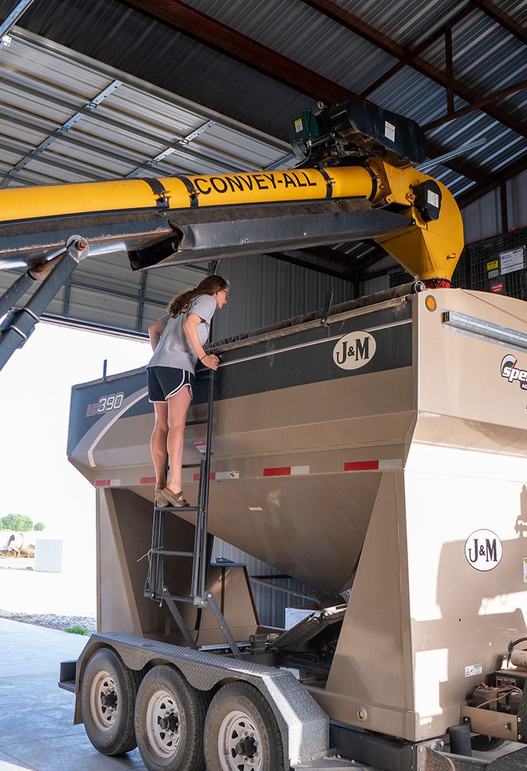 利兹·莫兰德监督大豆种子被存入种子传送机。一旦装满，她会把传送机送到丈夫詹姆斯那里种植。